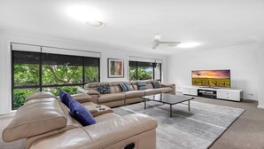 A modern living room with a leather sectional sofa, a coffee table, and a flat-screen TV.
