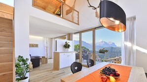Ein modernes Interieur mit Essbereich, Küche und Balkon mit Bergblick.