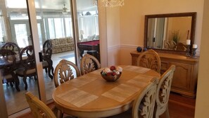 Un comedor con una mesa redonda, sillas y un cuenco decorativo.