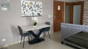 Een eethoek met een tafel, stoelen, een decoratief kunstwerk en een bank.