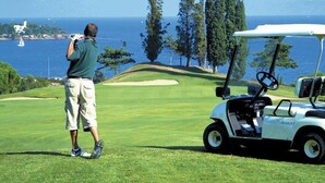 Golfkenttä, jolta avautuu näkymä merelle ja puustoon.