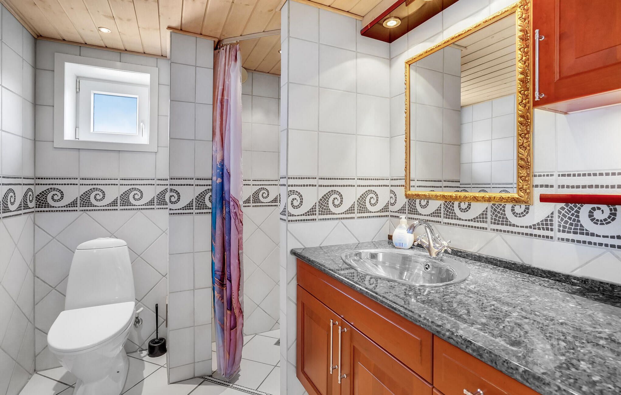 Un bagno con il water, doccia, lavandino e specchio.