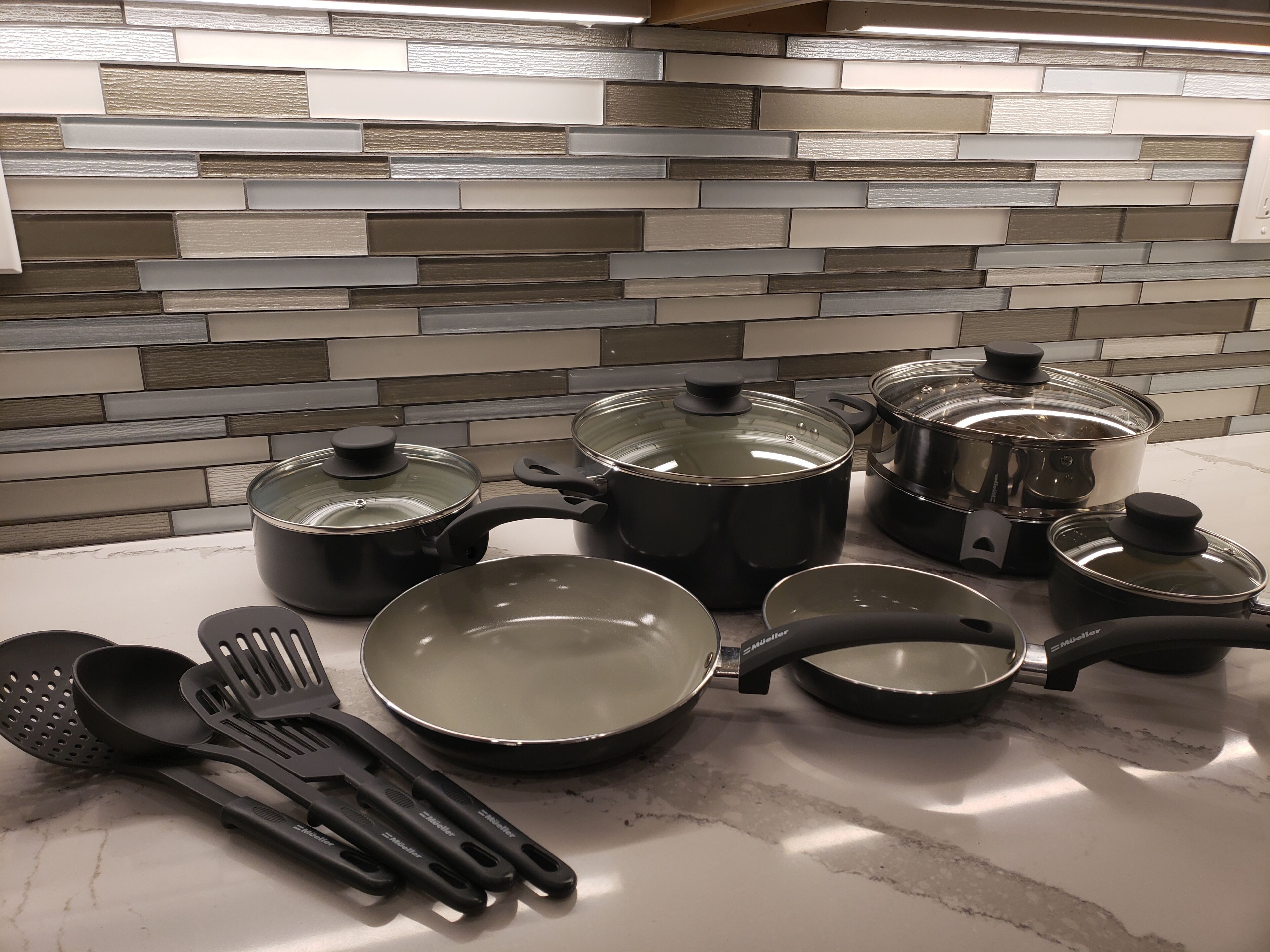 A kitchen with various cooking pots and pans on the counter.