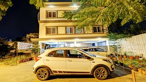A multi-story building with a car parked in front. - Itsy Hotels Colors Stay (Chikkamagaluru)