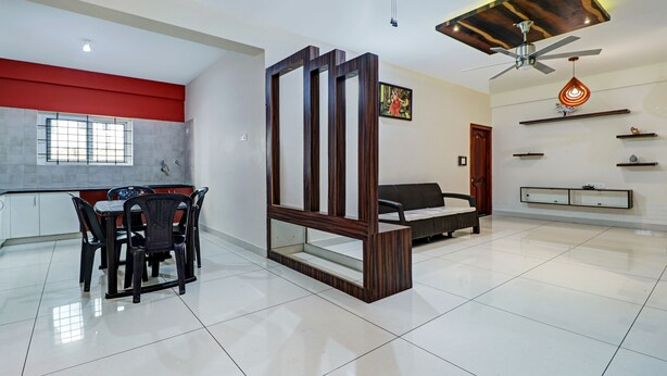 A modern living room with a dining area, a sofa, a coffee table, and a ceiling fan. - Itsy Hotels Colors Stay (Chikkamagaluru)