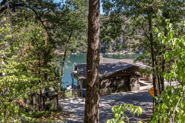 Una cabaña con un muelle que se adentra en un lago, rodeada de un bosque denso.