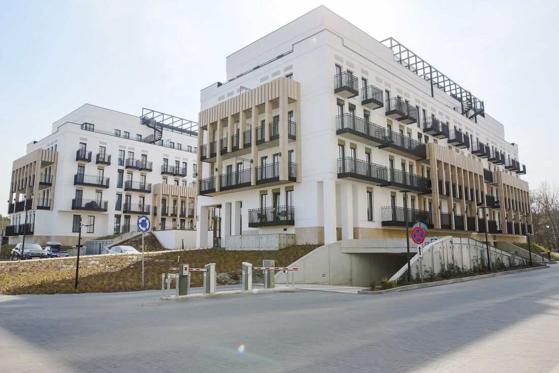 Un immeuble d’appartements moderne doté de nombreux balcons, d’une entrée sécurisée et d’un panneau indiquant qu’il est interdit de se garer.