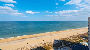 Uitzicht op het strand vanaf een hoog gebouw, met een heldere lucht.