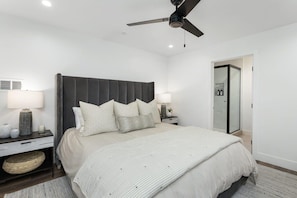 A bedroom with a bed, nightstands, a ceiling fan, and a bathroom door. - Lux Home 2 Huge Decks, AC, EV Chgr, Lake Access (Lake Arrowhead)