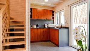 A modern kitchen with wooden cabinets, a built-in island, and a large window.