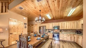 A wooden-paneled kitchen with a central island, built-in cabinets, and stainless steel appliances. - OM A8 Gruene River Two-Step at Old Mills Resort (New Braunfels)
