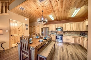 A wooden-paneled kitchen with a central island, built-in cabinets, and stainless steel appliances.