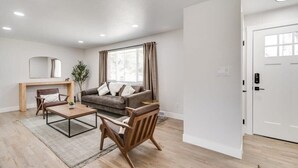 Un salon moderne avec un canapé, des fauteuils, une table basse et une cheminée.