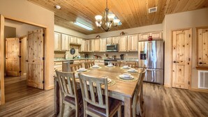 Una cocina amplia con armarios de madera, una isla central y un refrigerador de acero inoxidable.