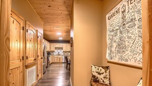 A hallway with wooden cabinets, a bench, and a wall with a map. - Old Mills Resort OM A5 3 Bedroom Condo by RedAwning (New Braunfels)