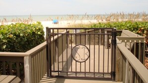 Entrada com portão para uma área de praia, com um logotipo no portão.