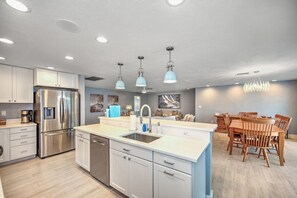 A modern kitchen with white cabinets, stainless steel appliances, and a central island. - Walking Distance to the Beach! Canal / Pool Home! (Marco Island)