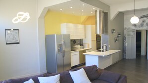 A modern kitchen with a built-in island, stainless steel appliances, and a yellow accent wall.