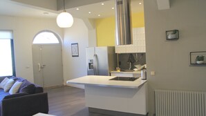 A modern kitchen with a central island, built-in appliances, and a pendant light.