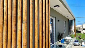 A modern building with vertical wooden slats, large windows, and a balcony with a glass railing. - Ionia's apartment,3 bedrooms,Next to all amenities (Missiria)