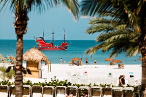 A beach with a red boat, lounge chairs, and umbrellas. - Charming Coastal House Near Beaches (Largo)