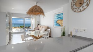 Una sala de estar moderna con una mesa de comedor de vidrio, un sofá y un reloj de madera grande en la pared.