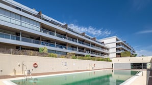A modern building with a swimming pool, multiple balconies, and a clear sky. - Punta Paloma Penthouse 2364 Sea View (Manilva)