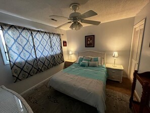 Cozy retreat with a single bed, bedside tables, and a ceiling fan.