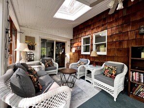 A cozy room with wicker furniture, a skylight, and wooden paneling.