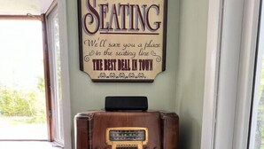 Ein altes Radio mit einem Schild darüber, auf dem steht: "Vorsitz reservieren" und "Wir reservieren Ihnen einen Platz in der Sitzreihenfolge. Das beste Angebot der Stadt!".