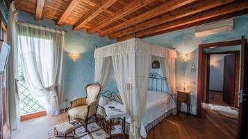Una camera da letto con un letto a baldacchino, un soffitto in legno e vista sull'esterno attraverso una finestra.