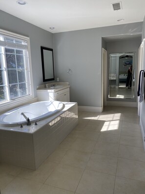 Enjoy a relaxing soak in the bathtub, surrounded by natural light and sleek design.