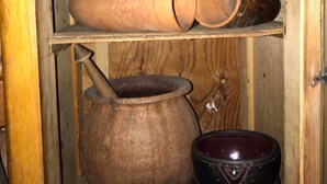 Un meuble en bois doté d’étagères où sont exposés des objets en céramique.