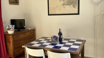 Enjoy meals for two at a dining table with a framed map and a television nearby.