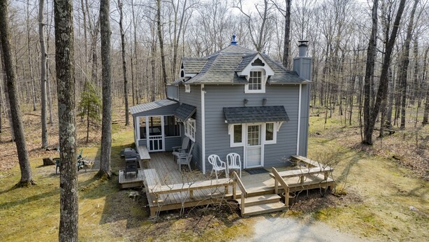 A small cabin with a deck, surrounded by trees. - Eagles Nest Cottage in Egg Harbor, Door County, WI (Egg Harbor)