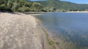 Une plage propre, avec un rivage sablonneux et une étendue d’eau calme.