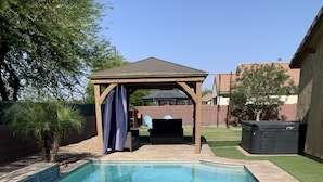 Una piscina rettangolare con acqua cristallina e azzurra, circondata da un solarium piastrellato.