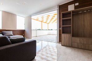 Suite estudio Deluxe, varias camas, vista al mar | Área de sala de estar | Televisión LED de 45 pulgadas con canales digitales y televisión 