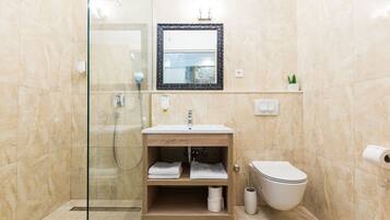 A modern bathroom with a glass-enclosed shower, a wooden vanity with a sink, and a toilet.