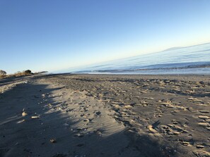 Une plage avec un ciel dégagé et une mer calme.