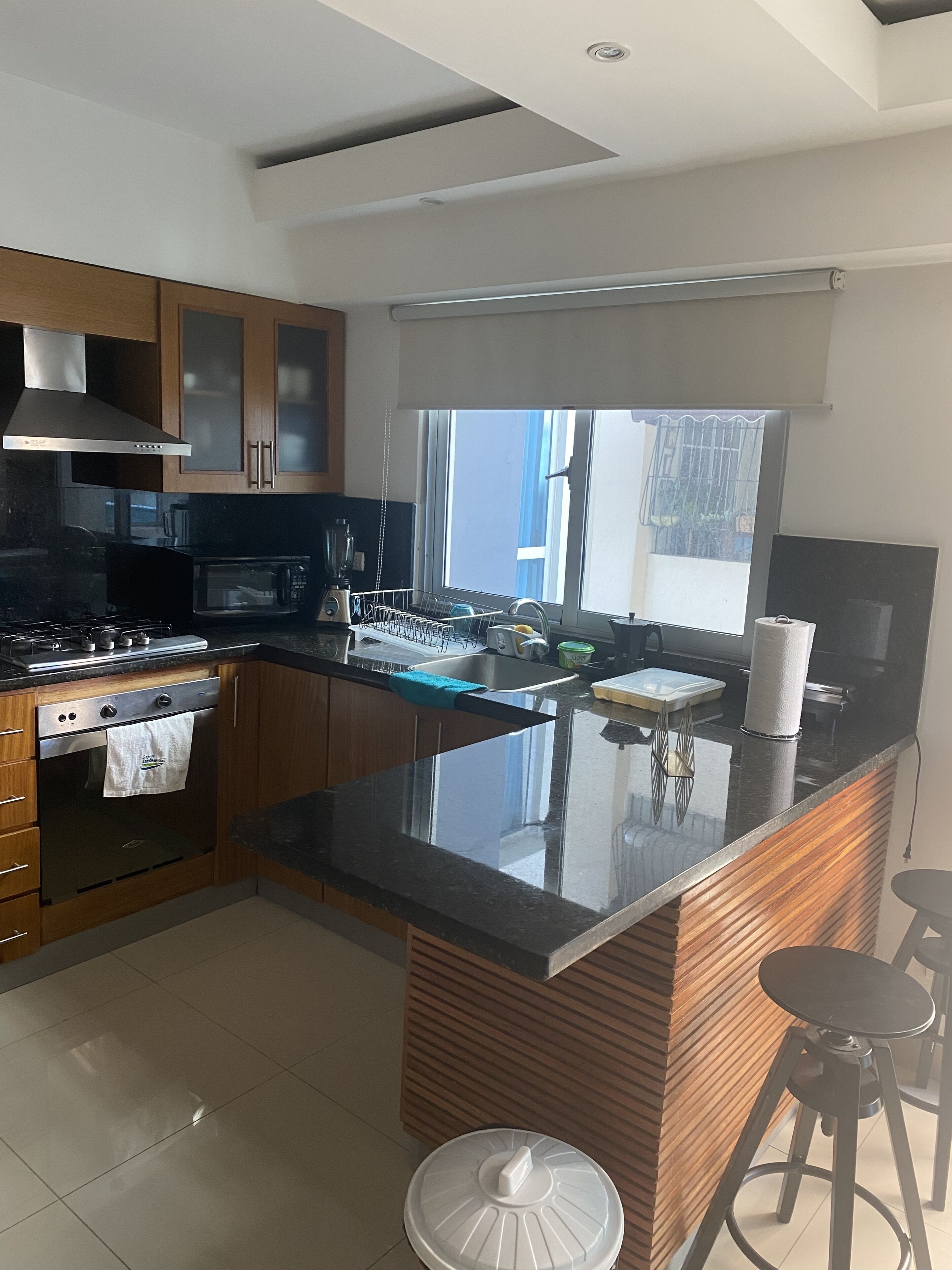 A modern kitchen with a central island, stainless steel appliances, and wooden cabinetry.