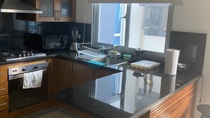 Una cocina moderna con una isla central, electrodomésticos de acero inoxidable y armarios de madera.