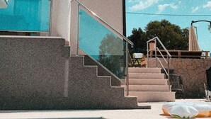 A modern building with a swimming pool, a satellite dish, and a staircase leading to a balcony. - Villa Oliwa (Vinisce)