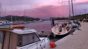 A marina with boats docked, a clear sky, and a rainbow. - Villa Oliwa (Vinisce)