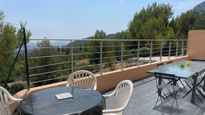 A terrace with a round table and chairs, a rectangular table with chairs, and a view of trees and hills. - T5 house overlooking Toulon harbour with swimming pool (Le Revest-les-Eaux)