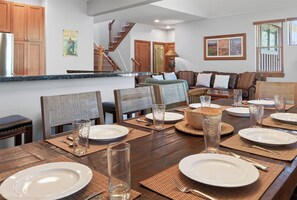 A dining area with a wooden table set for a meal, surrounded by chairs and a sofa. - Beautiful Home with New Private Hot Tub. Fireplace (Breckenridge)