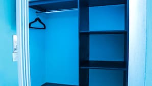A closet with multiple shelves and a hanging rod. - Ocean View Beach Hotel (Ocho Rios)