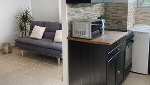 A modern kitchen with dark cabinetry, a built-in microwave, and a compact oven. - Lovely 2-room apartment in the heart of Esterel with swimming pool (Les Adrets-de-l'Estérel)