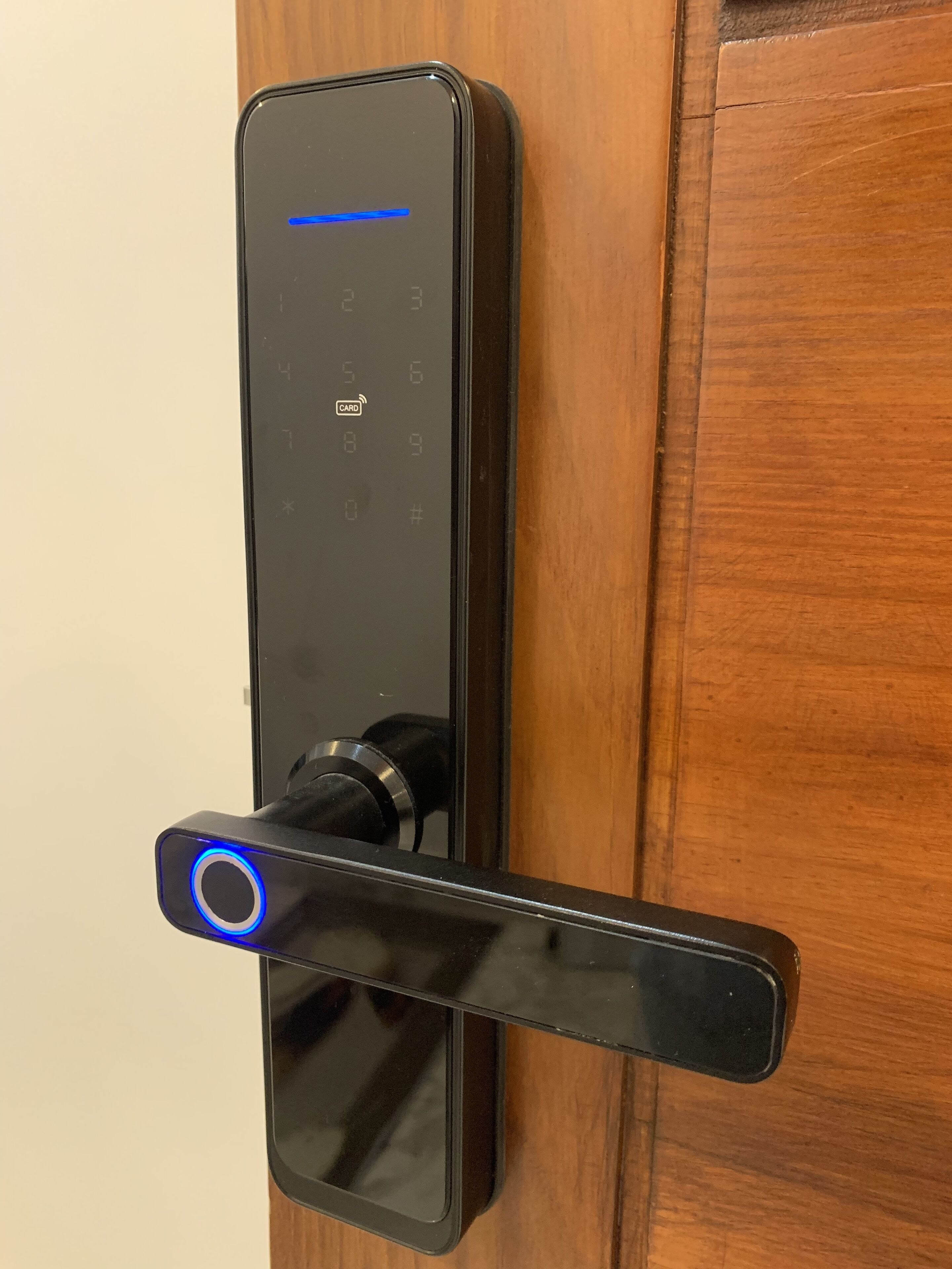 A modern, sleek door lock with a digital keypad and a card reader.