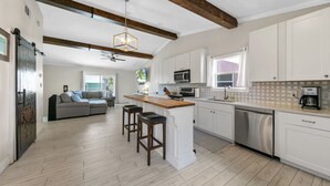 A modern kitchen with white cabinets, a wooden island, and a built-in oven. - Beach Side Destin Retreat (Destin)